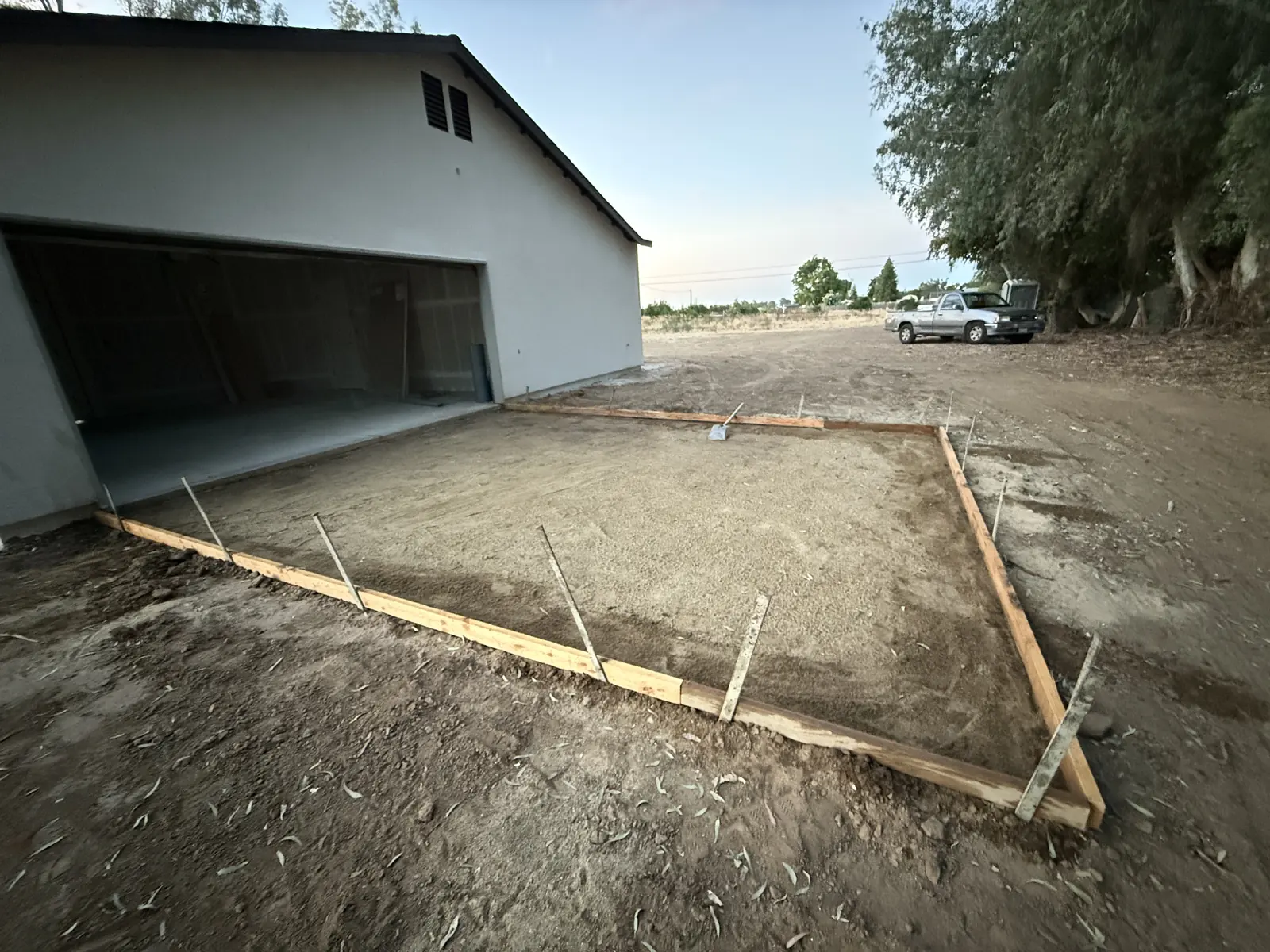 Graded base boxed in forms at the mouth of a detached garage