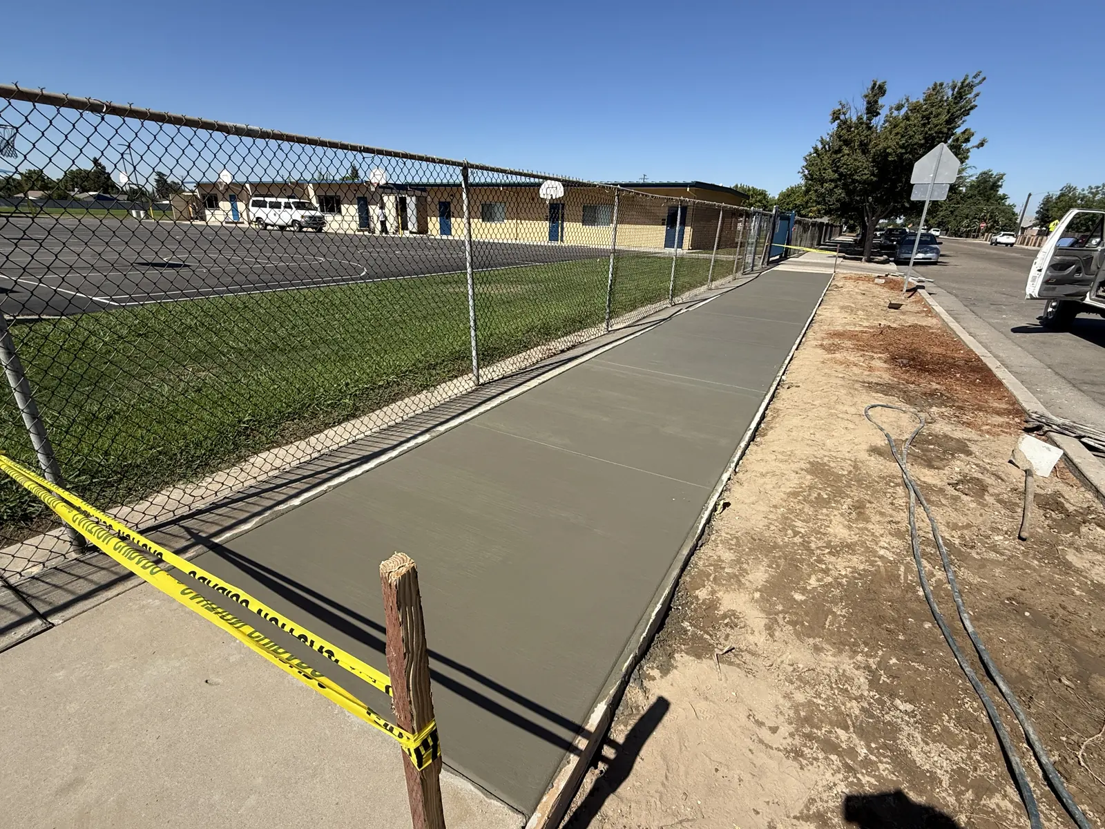 Long walkway poured along the playground fence and taped off to cure