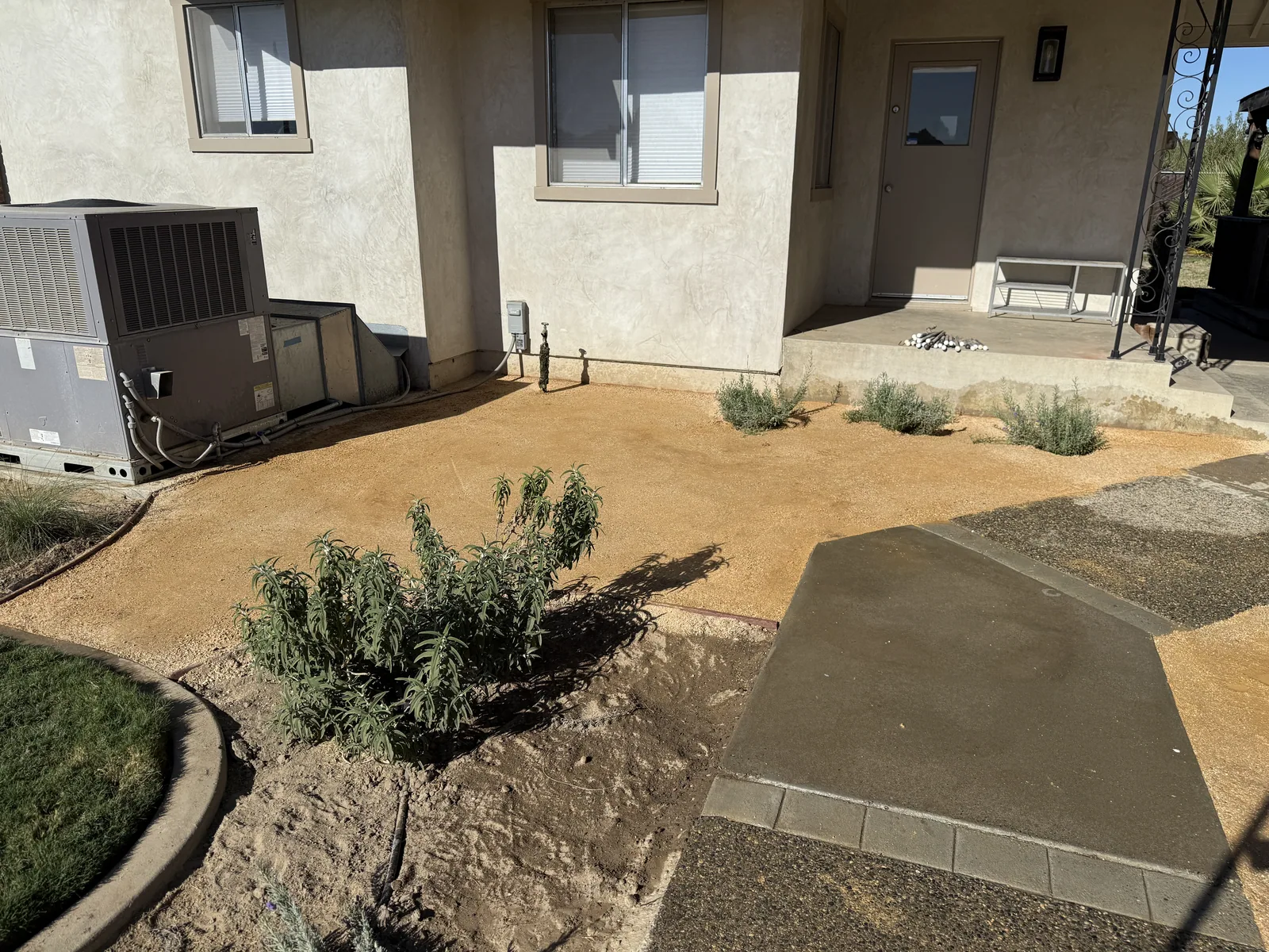 Finished walkway curving from the driveway to a stone veneer entry, edged against the lawn