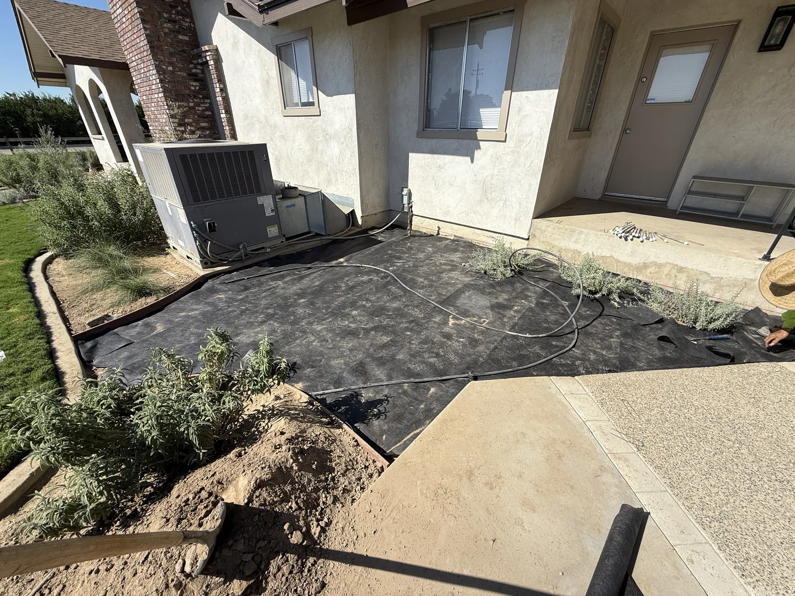 Wood forms and wire mesh staked out over graded soil where a curved entry walkway will be poured