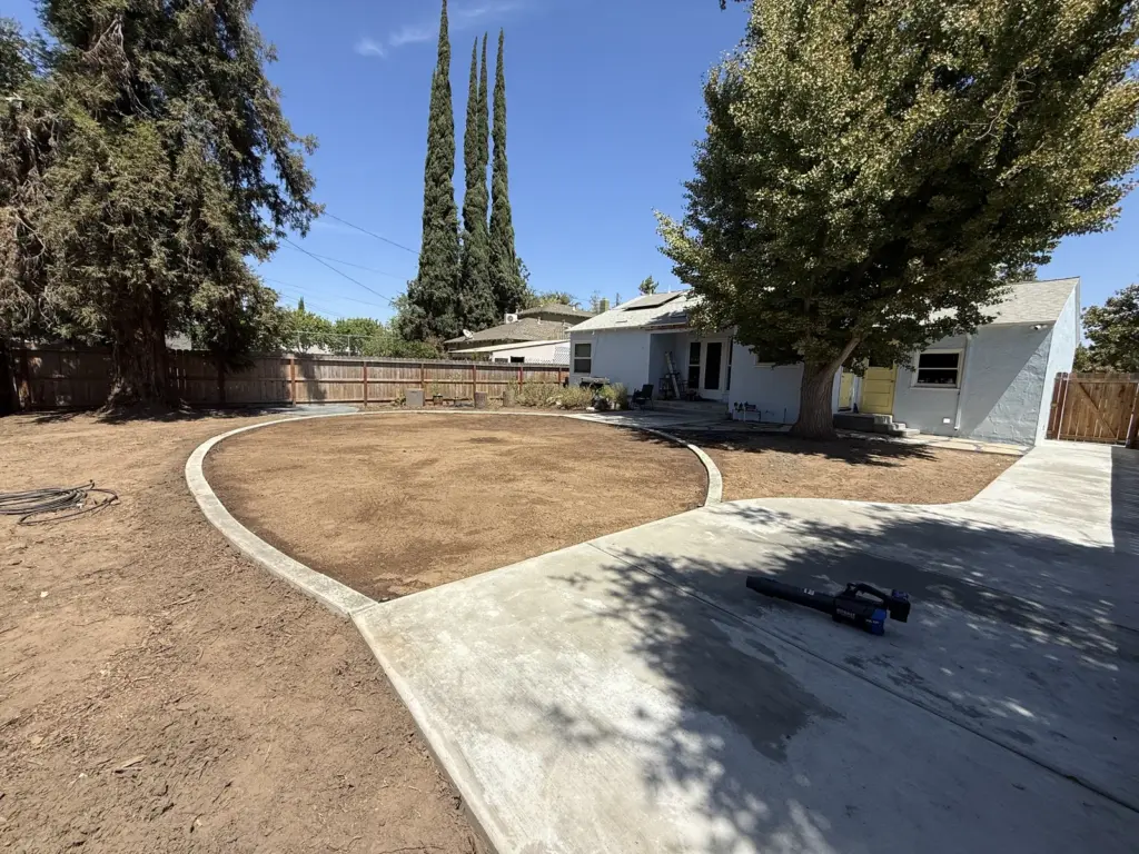 Rounded patio finished with a smooth curved edge meeting the prepared soil beyond