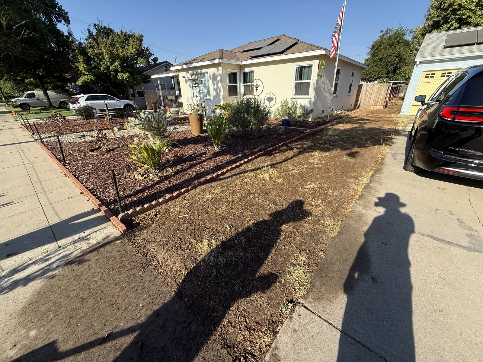 Wood forms and wire mesh staked out over graded soil where a curved entry walkway will be poured