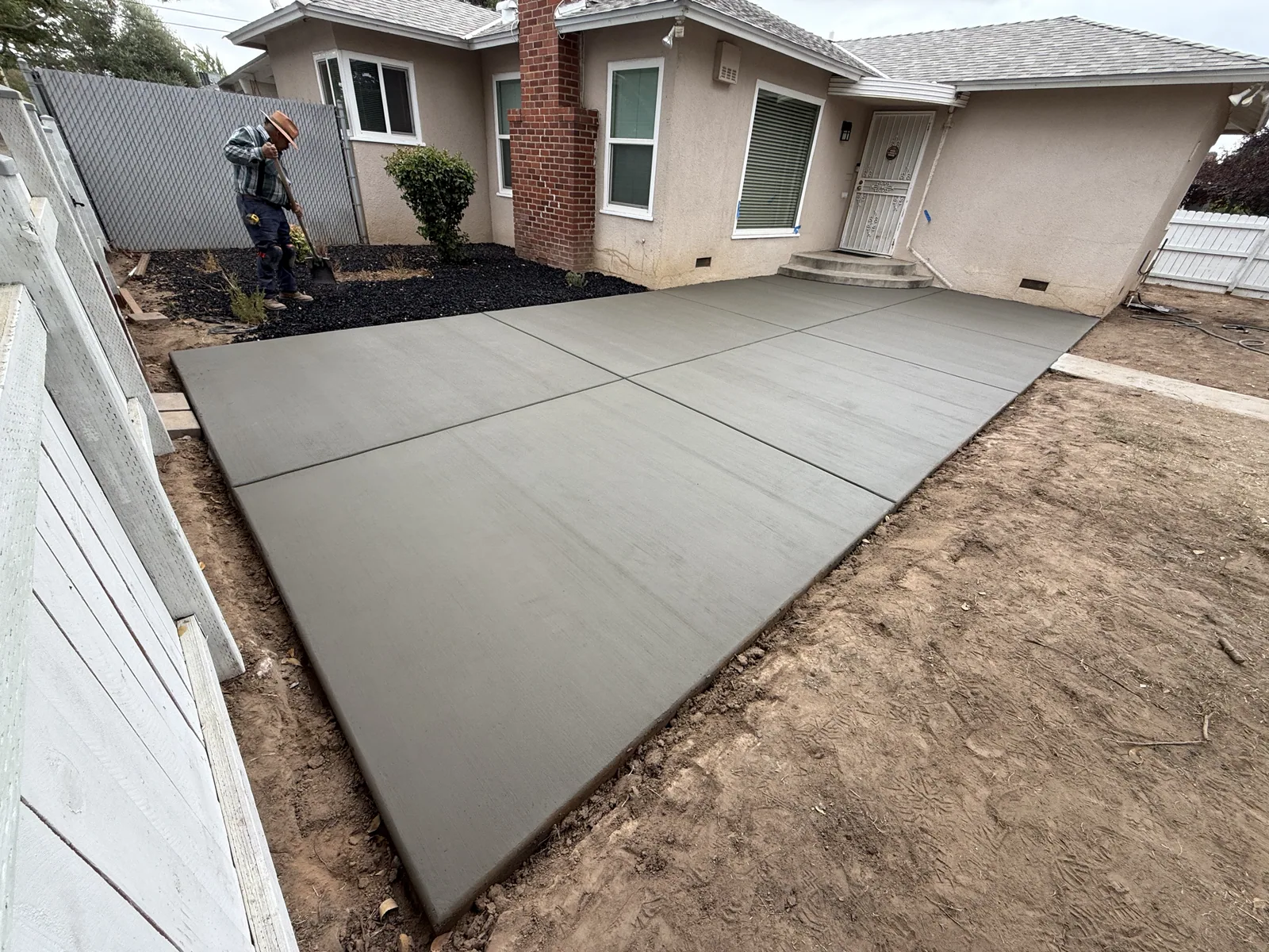 Finished walkway curving from the driveway to a stone veneer entry, edged against the lawn