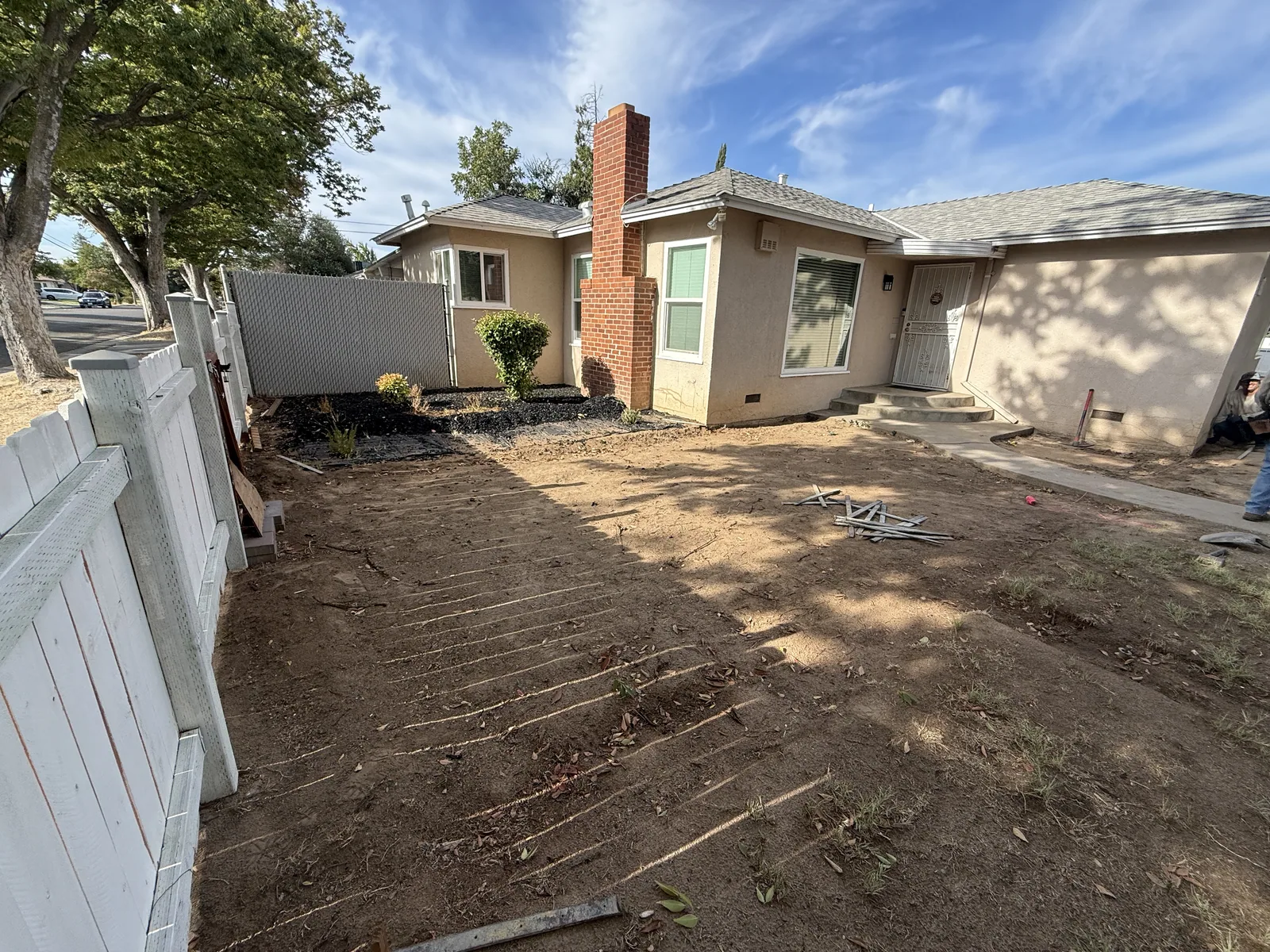 Wood forms and wire mesh staked out over graded soil where a curved entry walkway will be poured