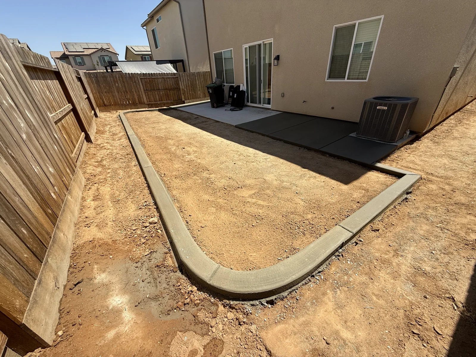 Finished walkway curving from the driveway to a stone veneer entry, edged against the lawn